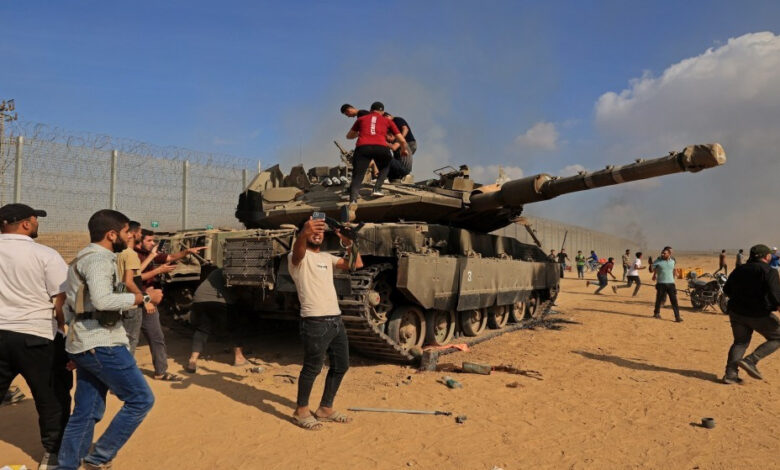 فلسطينيون يسيطرون على دبابة إسرائيلية من طراز ميركافا بعد عبور السياج الحدودي من خان يونس جنوب قطاع غزة، 7 تشرين الأول/أكتوبر 2023. (أ ف ب)